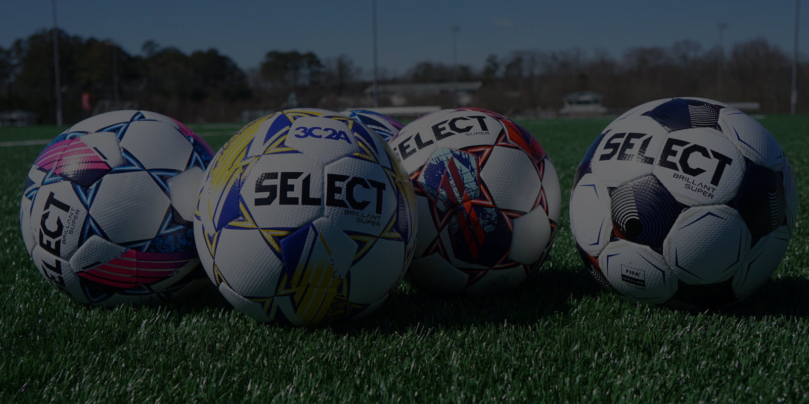 A variety of collegiate soccer balls on a soccer field