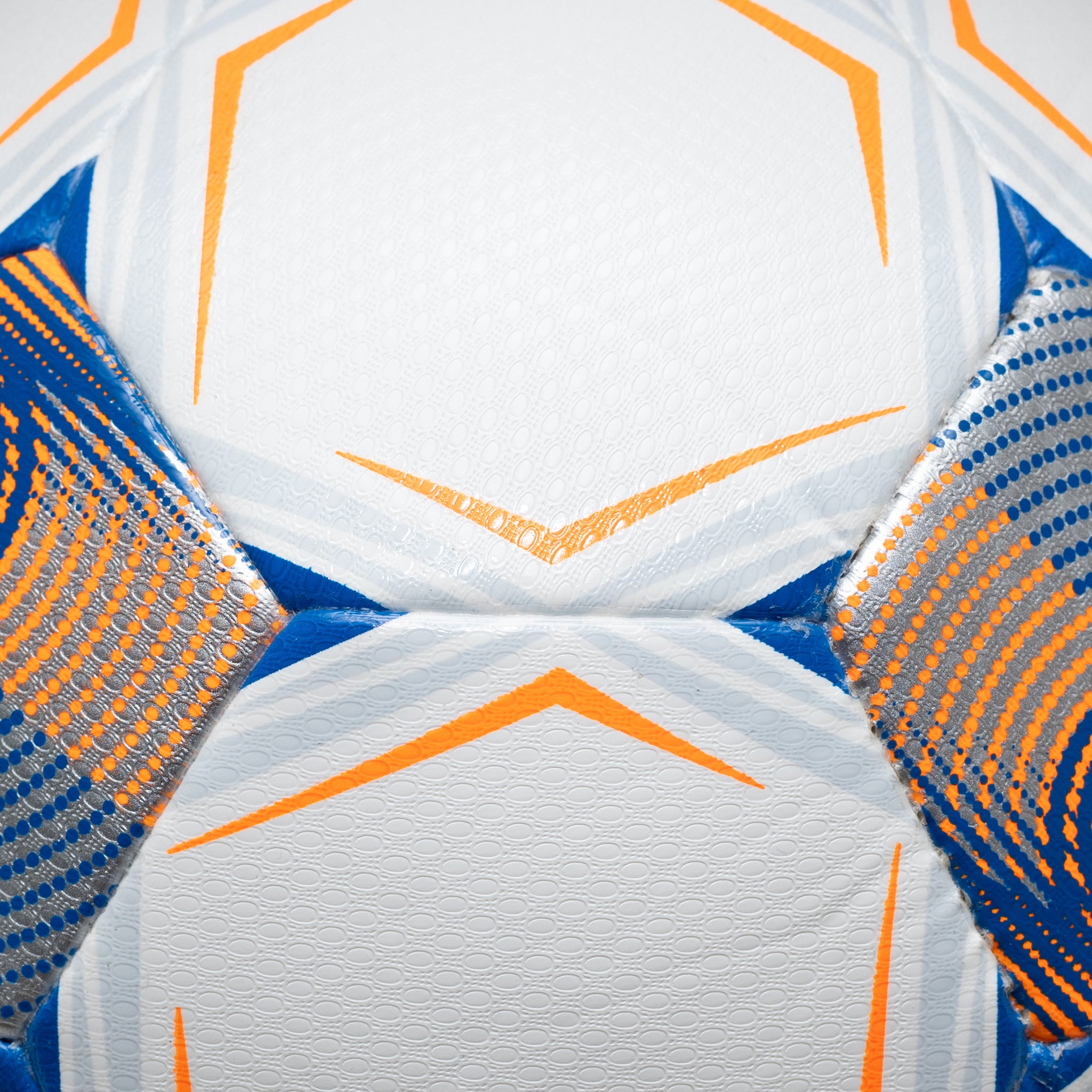 Closeup of white soccer ball with blue and orange accents