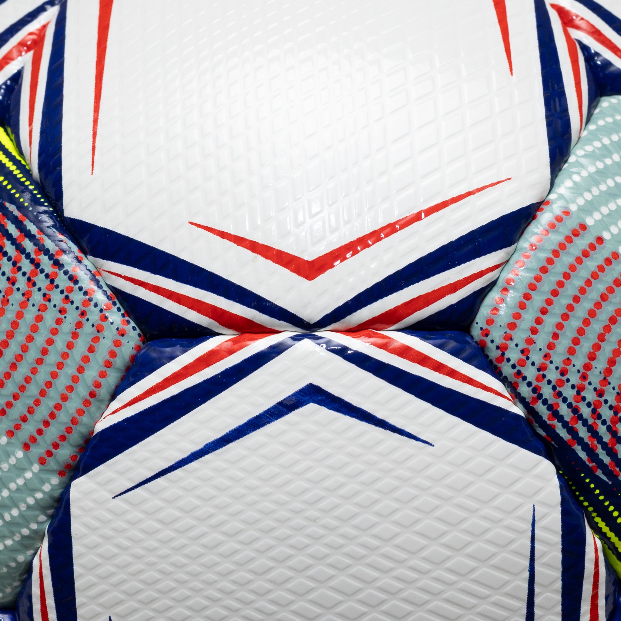 Closeup of Super v26 soccer ball, textured white panels with blue, red and yellow accents.