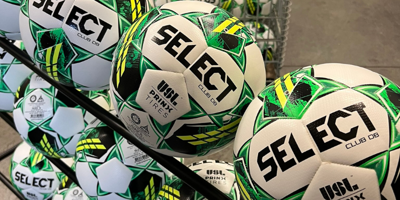 White and green 'SELECT, Club DB' balls that have been custom stamped with the 'USL, Prinx Tires' logo